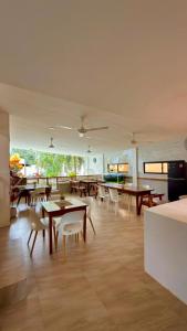 a dining room with tables and chairs and a room with windows at Ramz Residence in El Nido