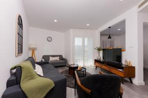 a living room with a couch and a tv at Perla Residence Hotel & SPA in Podgorica