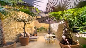 a patio with a table and chairs and plants at Le 215 Gambetta boutique hôtel en Provence in Cavaillon