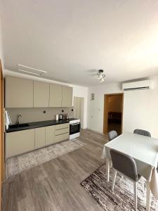 a kitchen and dining room with a white table at Dielli's house in Gnjilane