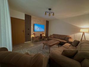 a living room with a couch and a tv at Dielli's house in Gnjilane