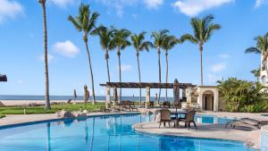a pool at the beach with palm trees at Las Mañanitas LM C208 in San José del Cabo