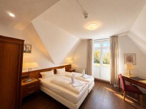 a bedroom with a white bed and a window at Hotel Kaiserhof in Lübeck +60 photos