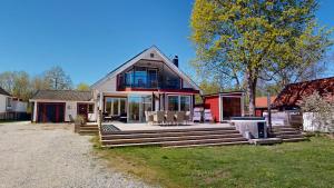 a home with a large deck with chairs on it at Villa Seeblick in Vissefjärda