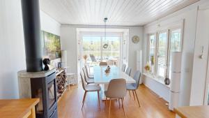 a kitchen and dining room with a white table and chairs at Villa Seeblick in Vissefjärda