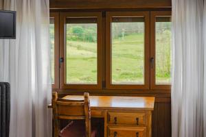 a wooden table with a chair in front of a window at Hotel Marqués de la Moral in Naveces