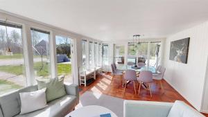 a living room with a couch and a table and chairs at Villa Waldsee in Vissefjärda