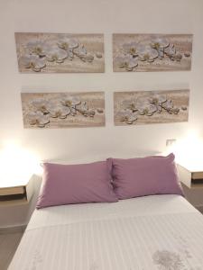 a bedroom with a bed with two paintings on the wall at Il sentiero delle fate in Caserta