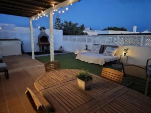 a patio with a bed and a table and chairs at Casita La Concha in Playa Honda