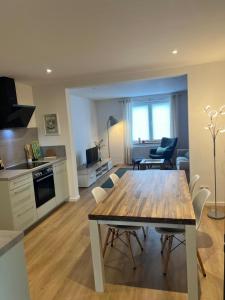 a kitchen and living room with a wooden table and chairs at Landliebe Wemb in Weeze