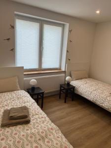 two beds in a room with two windows at Landliebe Wemb in Weeze