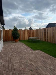 a backyard with a wooden fence and a picnic table at Landliebe Wemb in Weeze