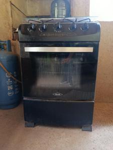 a black oven with its door open in a kitchen at Casa campo Villa Yaneth in Pueblo Bello