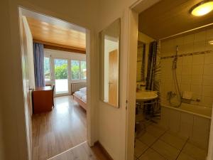 a bathroom with a shower and a sink and a toilet at Parkhotel Bellevue Budget in Lenk