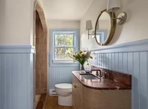 a bathroom with a sink and a toilet and a mirror at The Lightkeeper’s Inn in Edgartown