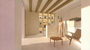 a woman standing in a room with a table and chairs at Malie Suites in Mikri Vigla