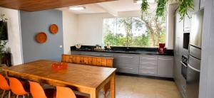 a kitchen with a wooden table and a large window at Bem-estar e boa localização (Apto Paraíso) in Maringá
