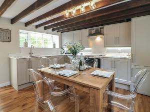 a kitchen with a wooden table and chairs at Lake Side Cottage in Wakefield