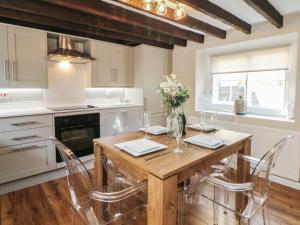 a kitchen with a wooden dining table and chairs at Lake Side Cottage in Wakefield +24 photos