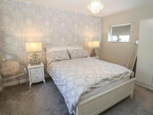 a bedroom with a bed with two night stands and two lamps at Lake Side Cottage in Wakefield