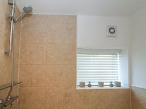 a bathroom with a shower with a window at Lake Side Cottage in Wakefield