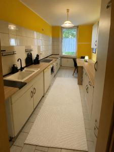 a kitchen with yellow walls and white cabinets and a sink at Adam's Sonnenberg Apartment in Chemnitz