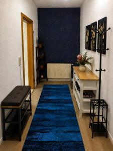 a living room with a blue rug and a table at Adam's Sonnenberg Apartment in Chemnitz