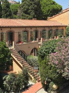a house with a staircase in a garden with flowers at Hôtel La Casa Pairal in Collioure