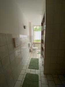 a bathroom with a toilet and two green rugs at Adam's Sonnenberg Apartment in Chemnitz