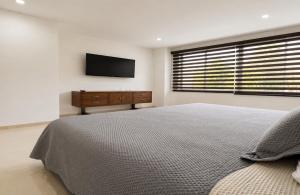 a bedroom with a bed and a television on the wall at Espectacular, Casa Vacacional Jpol in Cali +34 photos