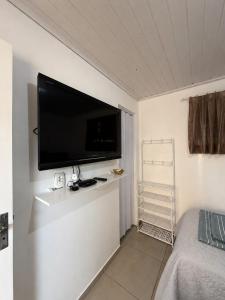 a flat screen tv on the wall of a bedroom at Studio Planejado no Centro de Campos Novos in Campos Novos +10 photos
