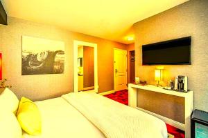 a hotel room with a bed and a flat screen tv at Hotel Kalika Inn in Dhanbād