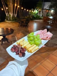 a plate of food with grapes and cheese and meat at Villa Chelsey in Valle de Ángeles