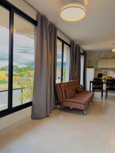 a living room with a couch and large windows at Ypê Flats e Containers in Bonito +45 photos