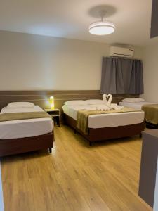 a hotel room with two beds and a window at Ypê Flats e Containers in Bonito