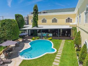 an exterior view of a house with a swimming pool at Hotel Mirador Plaza in San Salvador