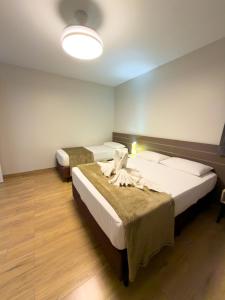 a hotel room with two beds and a light at Ypê Flats e Containers in Bonito