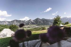 a person sitting on a bench looking at the mountains at Maiensäss, Berghütte Chlara - autark, voll ausgestattet, Ressourcen begrenzt in Untervaz