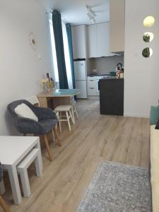 a living room with a table and a kitchen at Baza Ślęża , Nowoczesny Apartament w sercu Sobótki in Sobótka