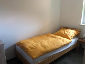 a bed with a yellow blanket on top of it at Ferienwohnung26 in Blankenfelde