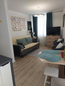 a living room with a couch and a table at Baza Ślęża , Nowoczesny Apartament w sercu Sobótki in Sobótka