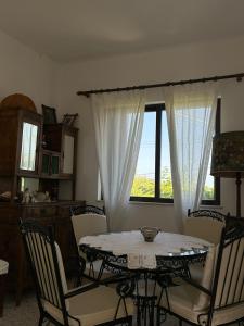 a dining room with a table and chairs and a window at Minimalist Serenity Vravrona - Airport Stay in Vravrona