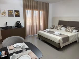 a hotel room with a bed and a table with plates on it at Mini B&B - Alessandro Volta in Rende