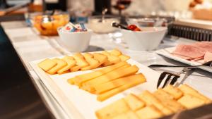 a buffet with cheese and meats on a table at Parkhotel Bellevue Budget in Lenk +64 photos