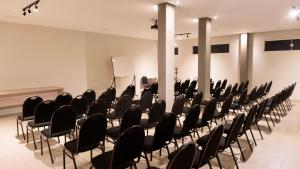 a conference room with black chairs and a podium at RILL HOTEL BY UCHÔA in Teresina +53 photos