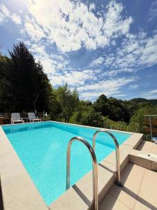 a large swimming pool with blue water in a yard at Vikendica Brda in Banja Luka