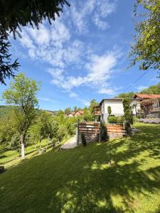 a yard with green grass and a house at Vikendica Brda in Banja Luka