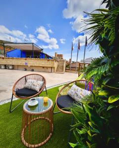 two wicker chairs and a table on the grass at El Mirador de Mesones in Mesones de Isuela