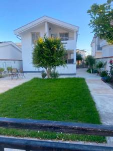 a house with a green lawn in front of it at Apartman Tara in Donji Štoj