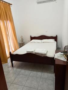 a bedroom with a bed with white sheets at Δειλινά in Platy